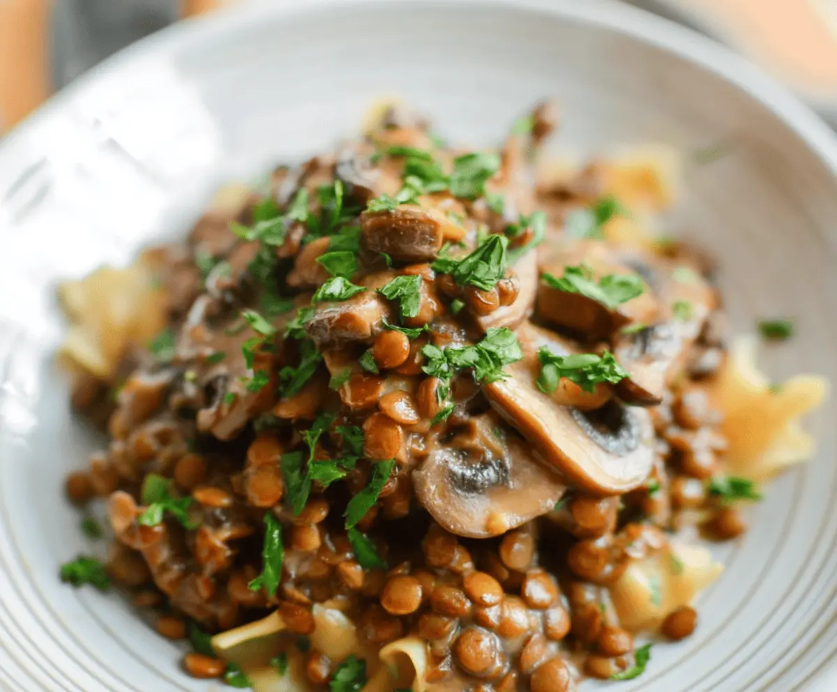 Creamy Lentil Mushroom Stroganoff served in a bowl topped with fresh parsley, showcasing a hearty vegetarian meal with tender lentils, sautéed mushrooms, and rich sauce.