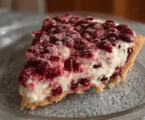 Delicious cranberry cheesecake pie with a golden crust and fresh cranberries on top.