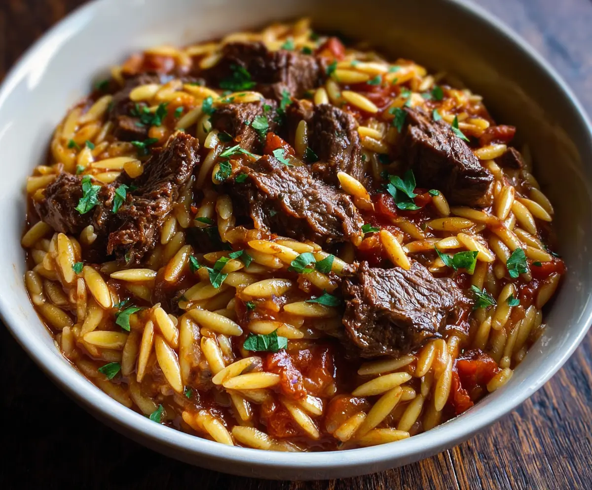 Delicious Beef Giouvetsi with Orzo, served in a rustic dish, showcasing tender beef and flavorful pasta.