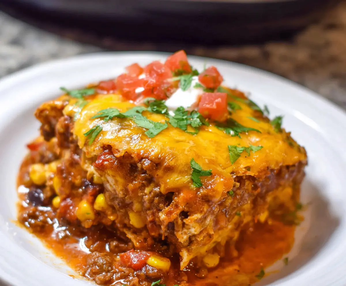 Delicious crockpot beef enchilada casserole with melted cheese and flavorful ingredients.