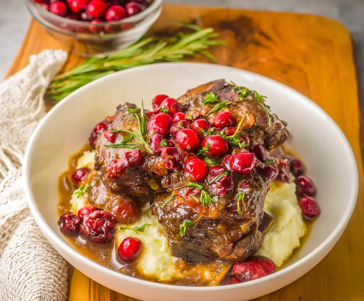 Delicious crockpot cranberry beef short ribs served with fresh herbs and vegetables