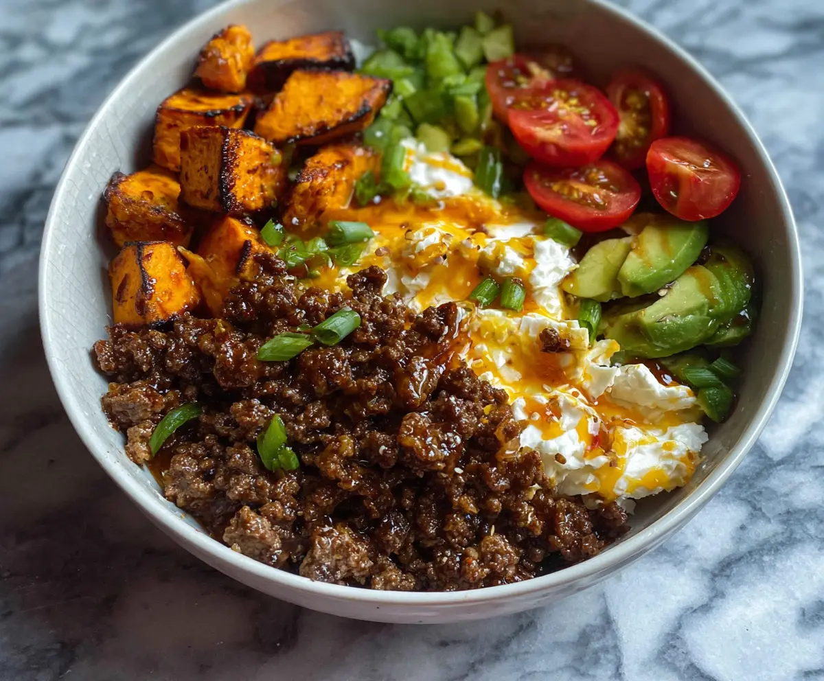 Delicious hot honey glazed ground beef served in a bowl with fresh vegetables and rice.