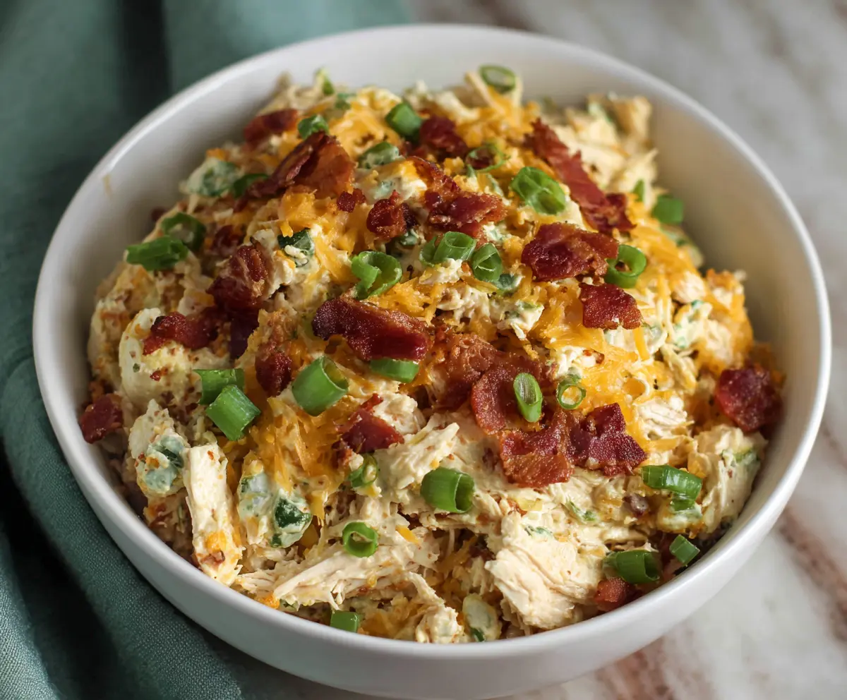Creamy Jalapeño Popper Chicken Salad garnished with fresh herbs and chopped jalapeños.