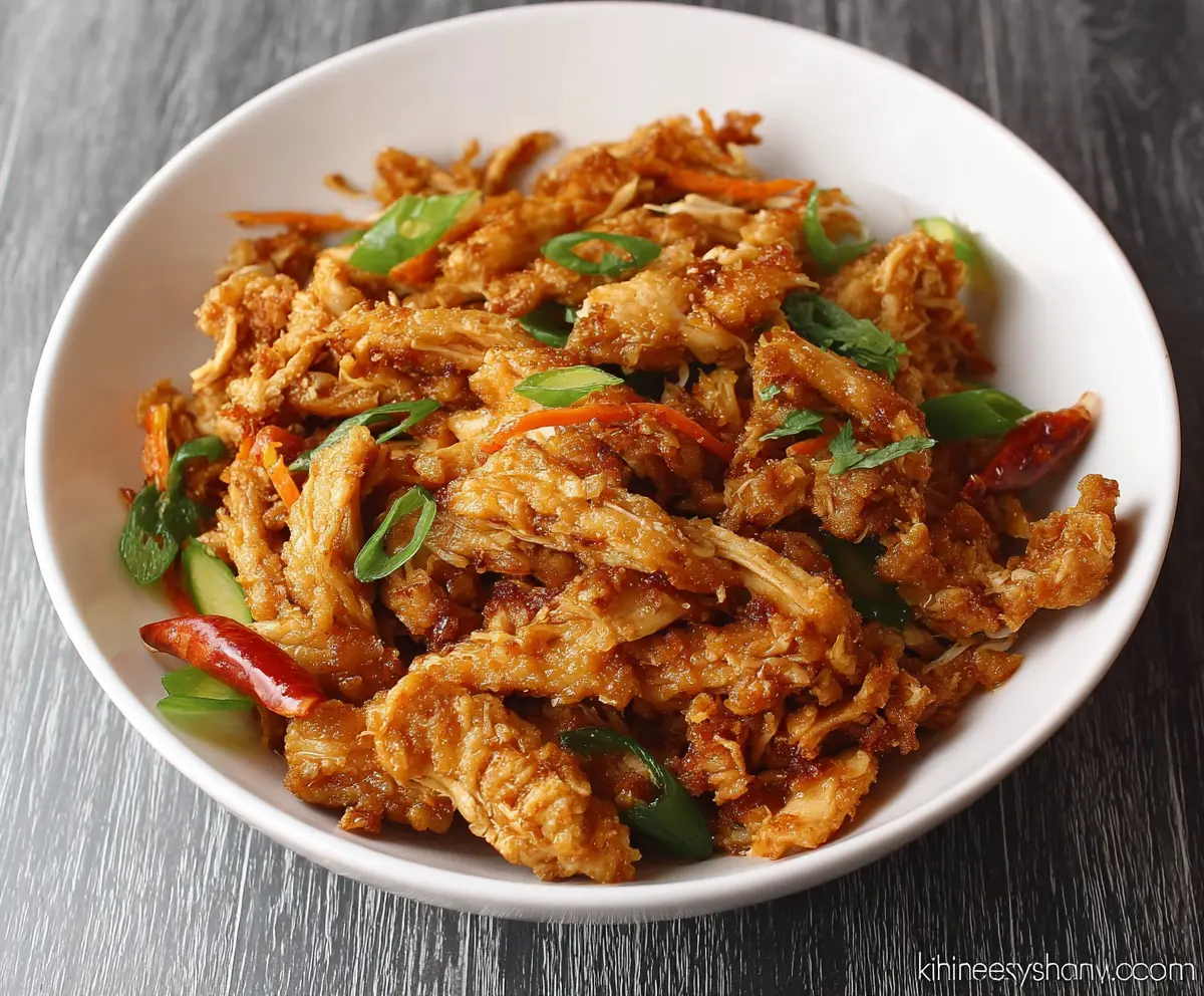 Crispy shredded chicken served on a plate with garnishes, perfect for a delicious meal