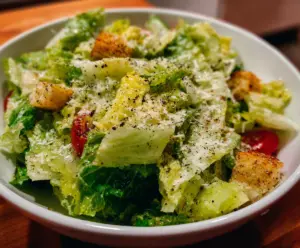 Fresh Nana's Crunchy Lemon Parmesan Salad topped with lemon wedges and grated Parmesan cheese.
