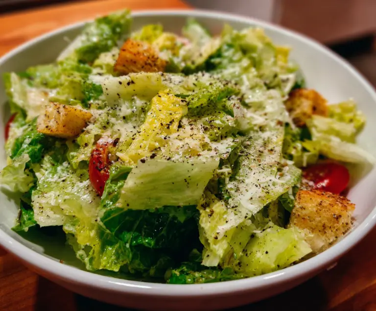 Fresh Nana's Crunchy Lemon Parmesan Salad topped with lemon wedges and grated Parmesan cheese.