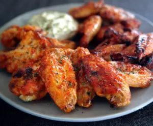 Crispy Buffalo Wings with spicy buffalo sauce served with celery sticks on a plate
