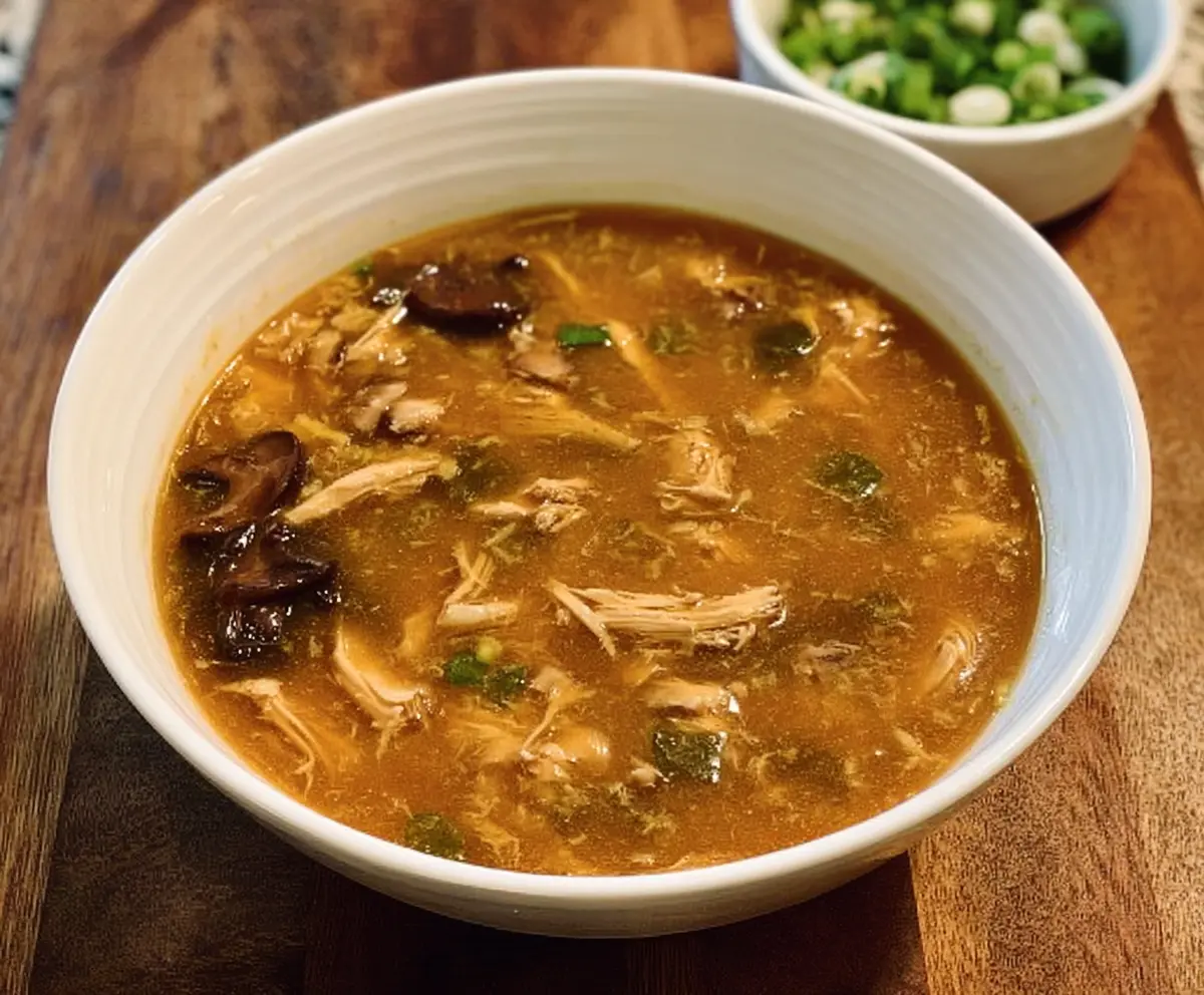 Delicious Instant Pot hot and sour chicken soup with vegetables and herbs in a bowl