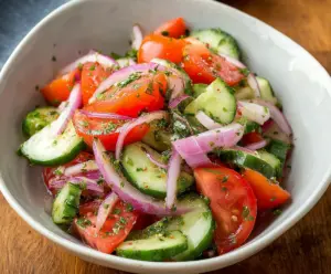Vibrant cucumber, tomato, and red onion salad perfect for summer refreshment.